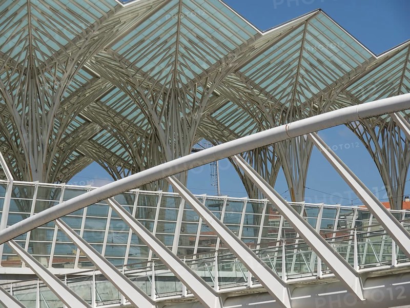 Architectural details of a modern structure with glass roof and steel construction against blue sky, Lisbon, portugal