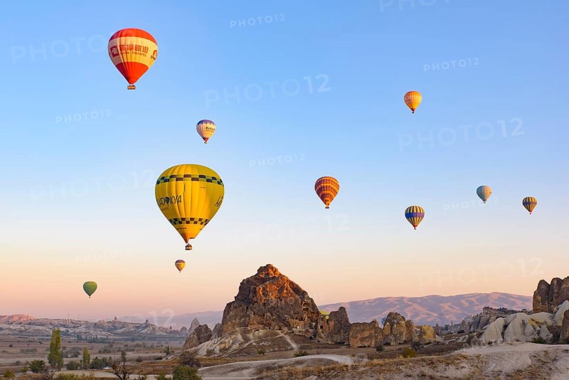 Flying hot air balloons and rock landscape at sunrise time in Goreme, Cappadocia, Turkey, Asia