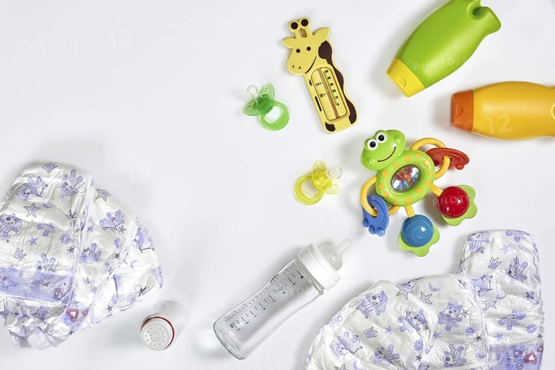 Set of accessories for baby. Pacifier, bottle, diaper, cream on white background. Maternal concept top view