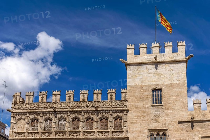 Tower with the flag of Valencia on the richly decorated brick building of the Algemesí School in Pl. del Mercat with blue sky in the background in the centre of the old town, Valencia, Autonomous Community of Valencia, Province of Valencia, Spain, Europe