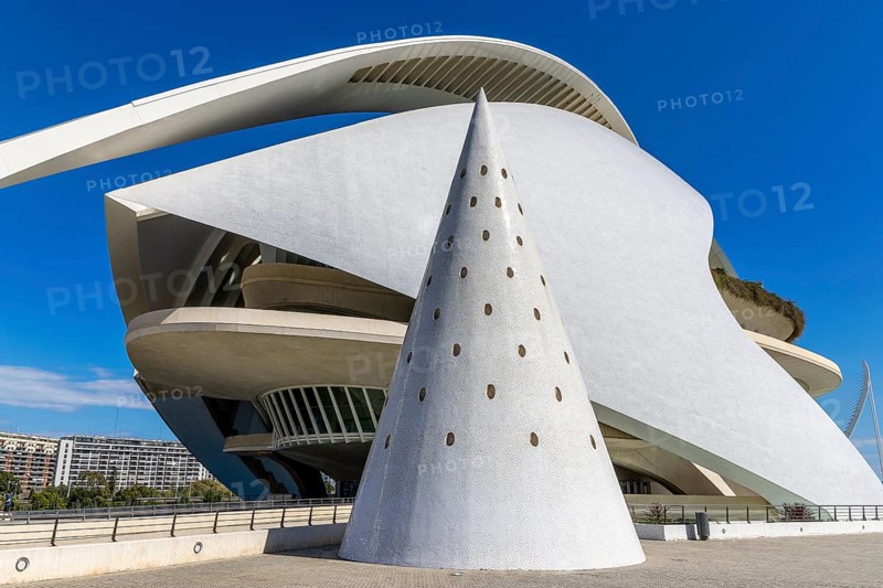 Conical decoration lined with white ceramic tiles and in the background is the modern architecture building futuristic cultural centre Palau de les Arts Reina Sofía (Palau de Les Arts Reina Sofía) with the blue sky in the background in the ultra-modern science complex in a landscaped park Ciudad de las Artes y de las Ciencias, Quatre Carreres, Valencia, Valencian Community, Valencia, Spain, Europe