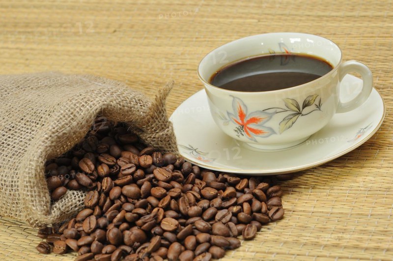 Coffee beans next to a coffee cup. Freshly ground coffee, Coffee beans next a coffee cup. Freshly ground coffee to