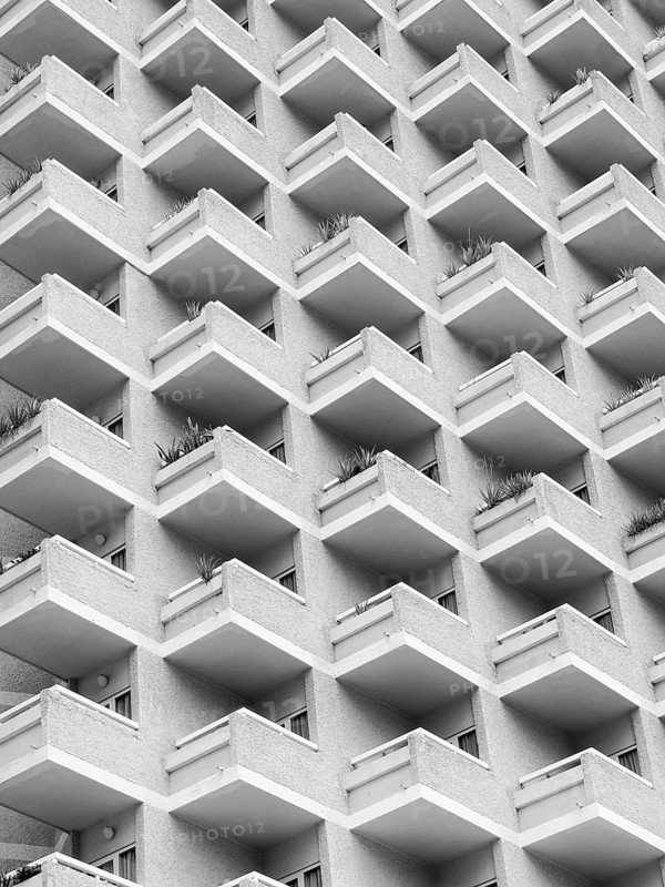 High rise building with residential flats or apartments in a white concrete development with balconies