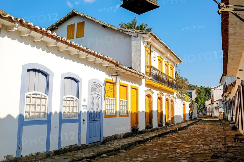 Typical colonial two and one story houses with colorful doors and windows on sunny day in historic town Paraty, Brazil, Unesco World Heritage, South America