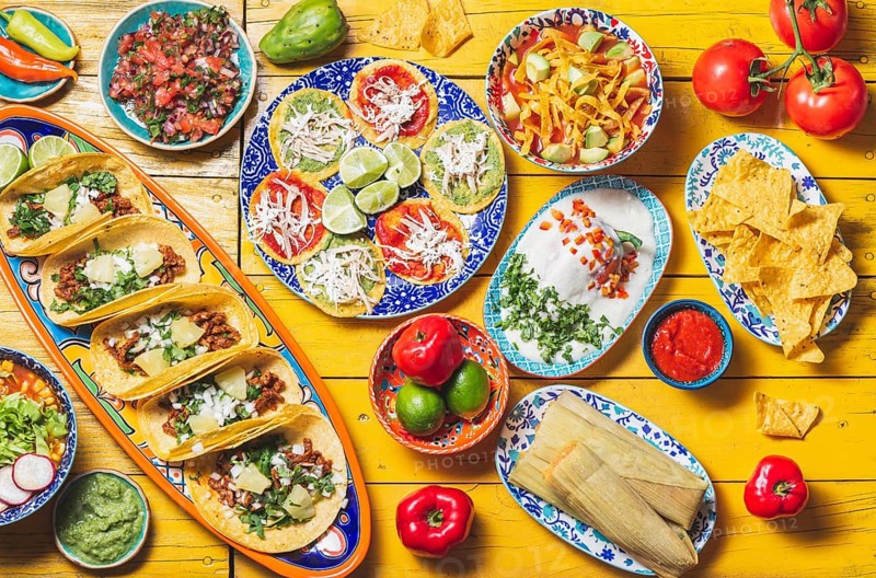 Food, Mexican festive food for independence day, independencia chiles en nogada, tacos al pastor, chalupas pozole, tamales, chicken with mole poblano sauce. Yellow background