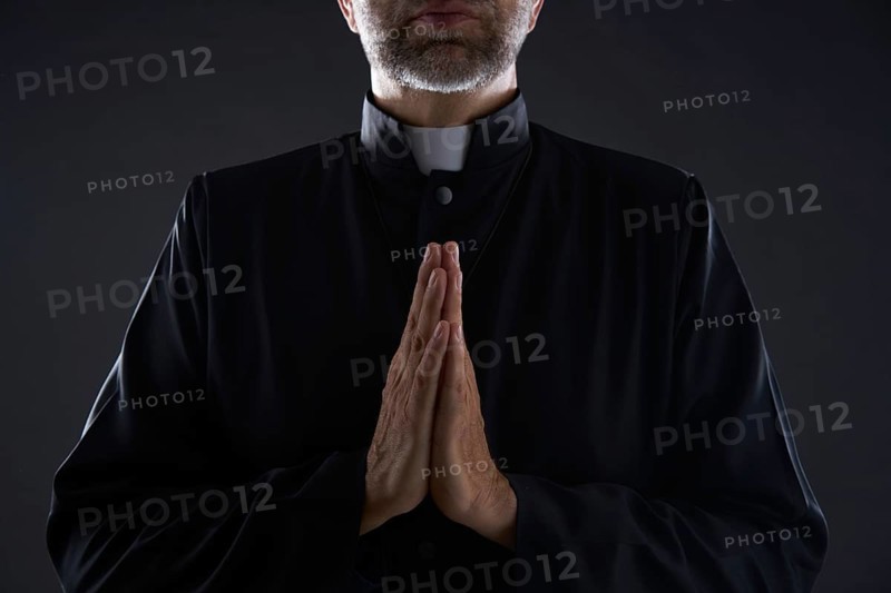 Praying hands priest portrait of male pastor