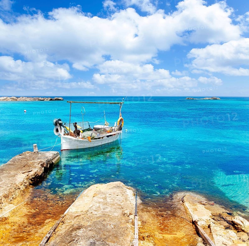 Els Pujols beach in Formentera with traditional fishing boat in summer day