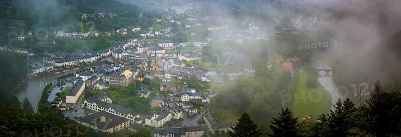 Bouillon, Belgium, 04th of August 2023: High angle viewpoint on the city of Bouillon in the Ardennes, Wallonia, Belgium. Rainy and cloudy day covering the city in fog, Europe