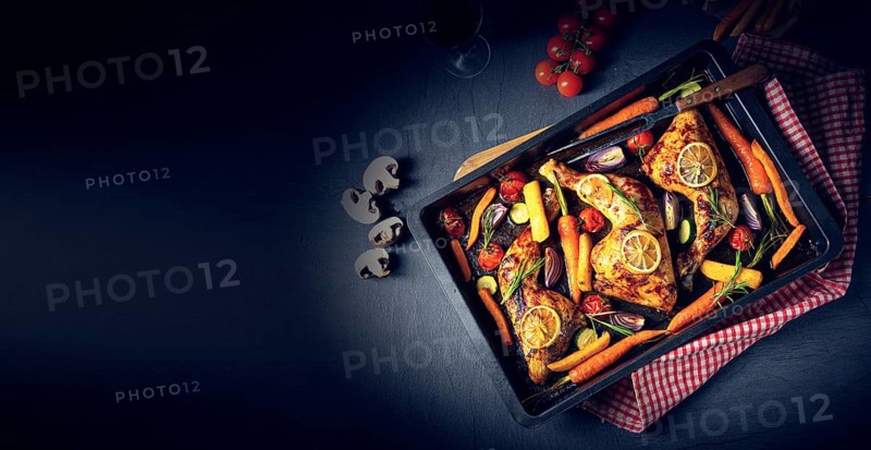 Grilled chicken legs with various vegetables and herbs