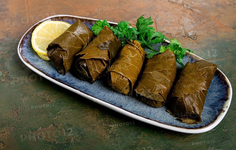 Dolma, minced meat with rice, in grape leaves, rolls with minced meat, on a plate, top view, no people, tolma, grape leaves with filling