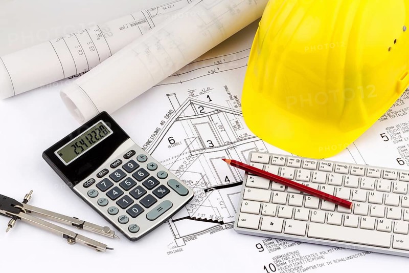An architect's construction plan with a builder's helmet. Symbolic photo for financing and planning a new house