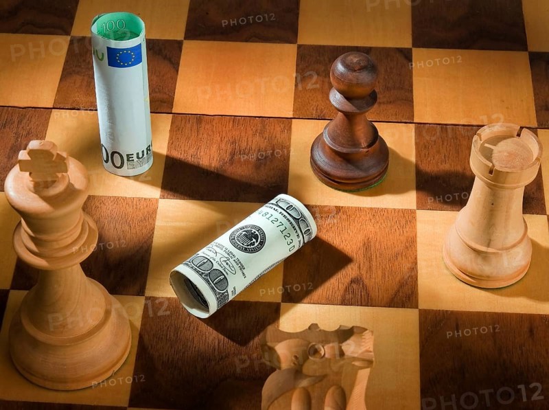 Chess with dollar and euro banknote. Symbol for devaluation of the dollar against the euro. Austria