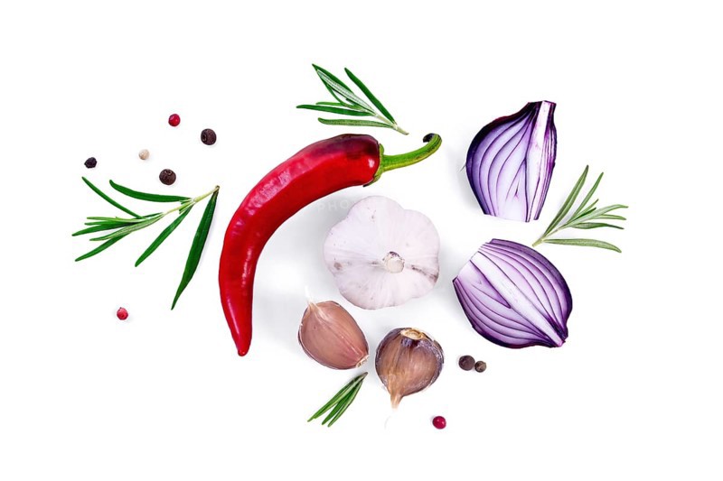 Pod of red hot pepper, slices of purple onion with sprigs of rosemary, garlic and peas of colored pepper isolated on white background