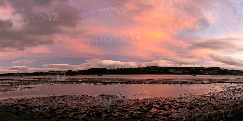 A panorama view of the Clyde River near Dumbarton at low tide at sunset