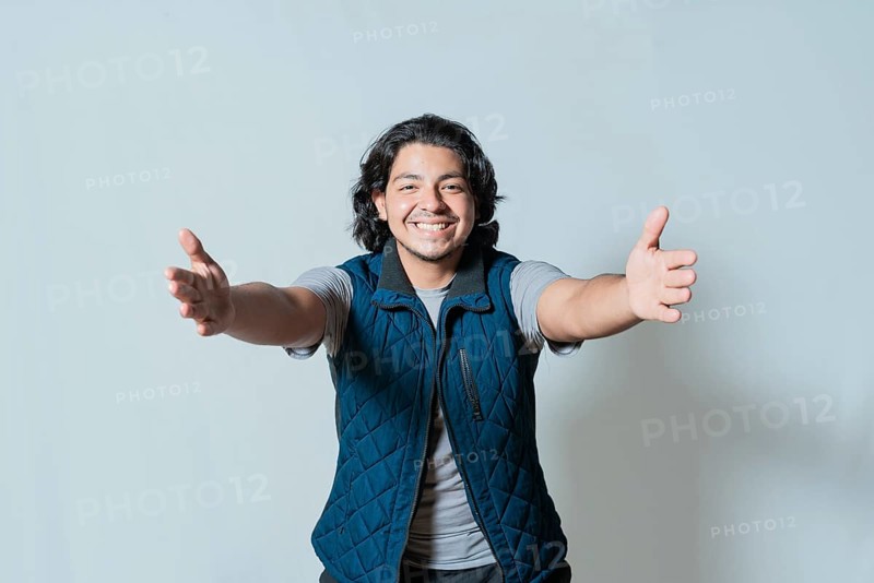 Happy young man welcoming with open arms isolated. Hospitable person opening arms to the camera