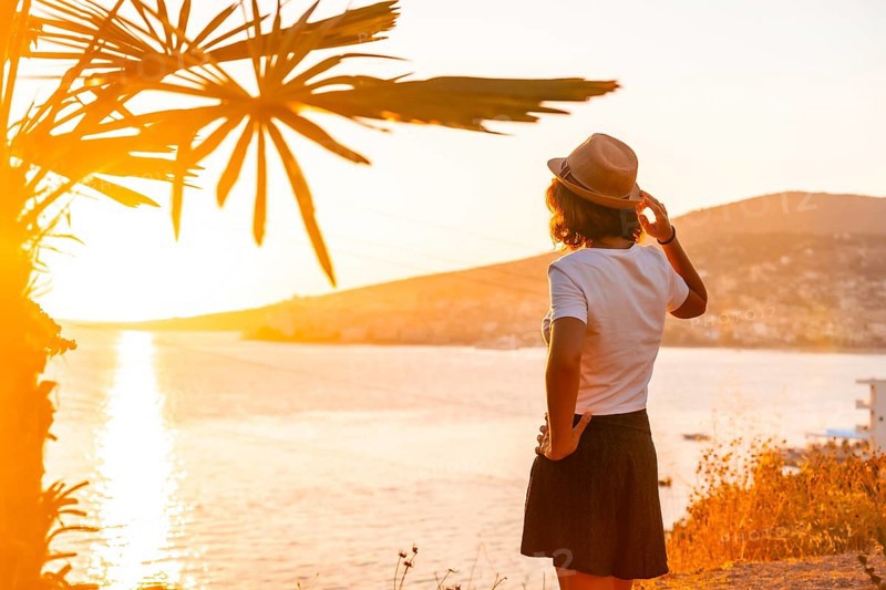 Panoramic view of the city and a tourist woman at sunset of Sarande or Saranda on the Albanian riviera, Albania