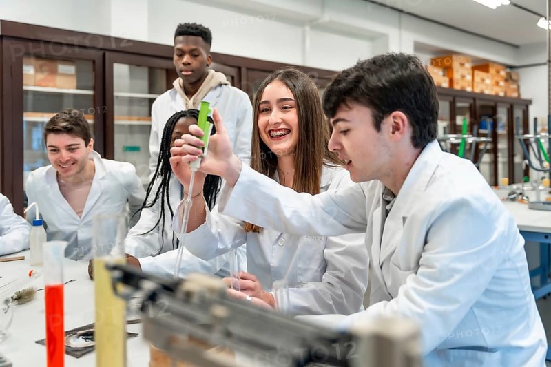 Diverse group of university chemistry students conducting an experiment in a lab, using lab coats and equipment, showcasing teamwork and scientific inquiry