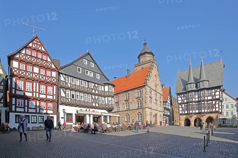 Historic Bücking House with street pub, Gothic Renaissance wine house built in 1539 and half-timbered town hall built in 1516 with turrets and decorations, church tower of the people, pedestrians, tourists, gastronomy, market square, Alsfeld, Vogelsberg, Hesse, Germany