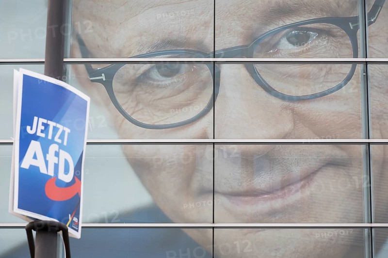 An election poster of the far-right AfD party (now AfD) hangs in front of a portrait of Friedrich Merz, the party chairman of the CDU, in front of the Konrad Adenauer House. Just after the 80th anniversary of the liberation of the Auschwitz concentration camp, the CDU chairman tabled a motion in favour of a tougher migration policy, which was only won thanks to the votes of the AfD. Berlin, 01.02.2025