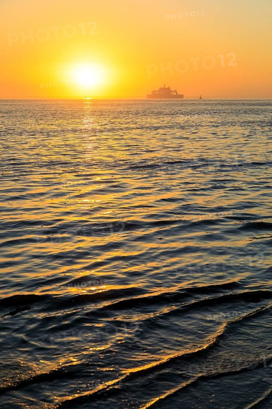 Ferry and sunset on the west coast of Norderney, Lower Saxony, Germany