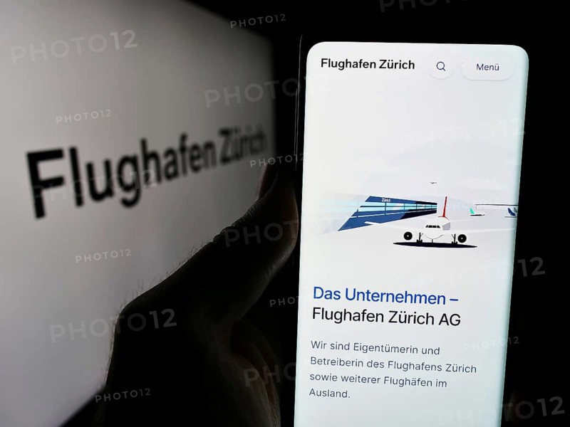 Stuttgart, Germany, 05-31-2024: Person holding smartphone with website of Swiss airport operator company Flughafen Zürich AG (FZAG) with logo. Focus on centre of phone display
