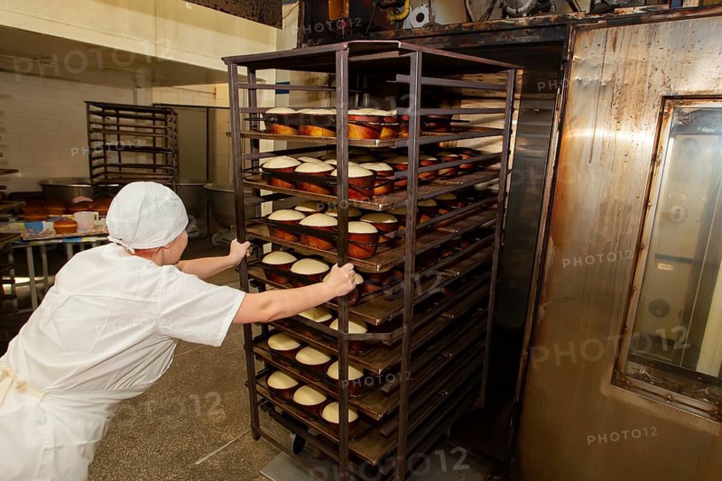 Belarus, the city of Gomil, April 25, 2019. Bakery.A bakery worker places trays with raw bread in the oven. Industrial production of bakery products
