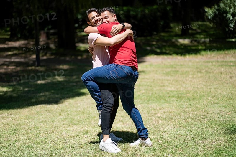 Couple of latin men hugging in a park
