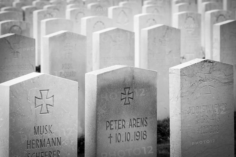 A black and white photo of a First World War military cemetery with rows of gravestones and crosses, France. The graves mark the burial places of both German and British soldiers