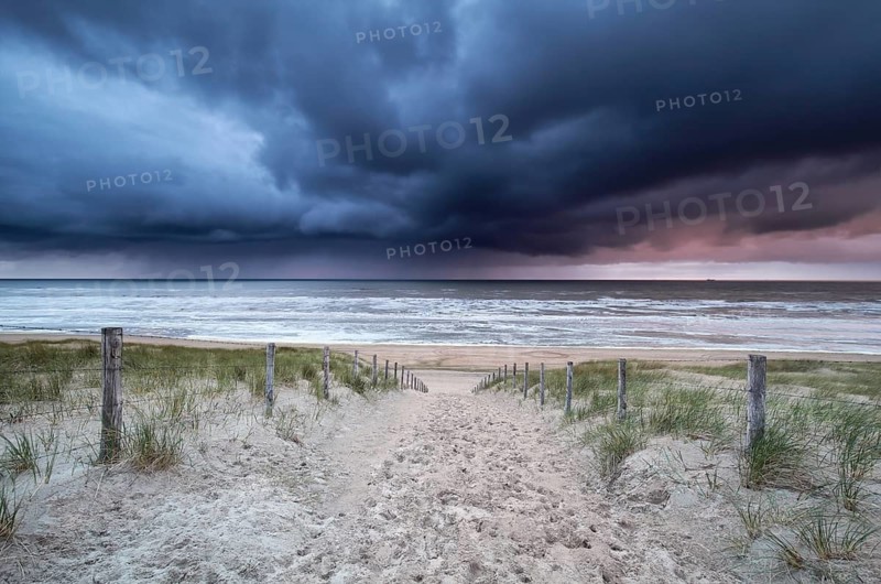 Stormy sky and showers over North sea beach, Netherlands