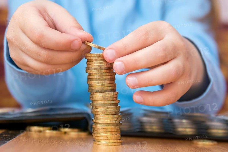 Child amassed a large pile of gold coins, close-up