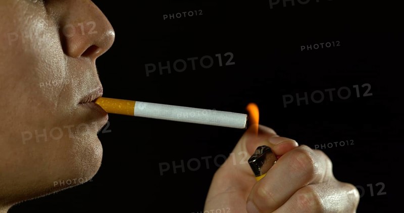 Woman smoking a Cigarette against Black Background