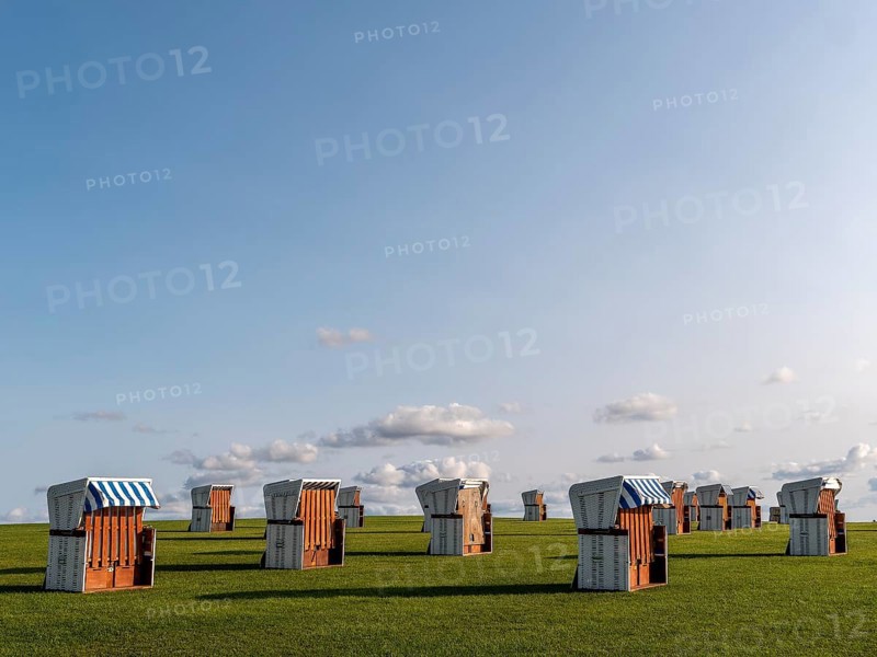 White beach chairs on a meadow and blue sky with clouds in the background, along the coast of the Unesco World Heritage Wadden Sea, Büsum, North Sea, North Frisia, Schleswig-Holstein, Germany