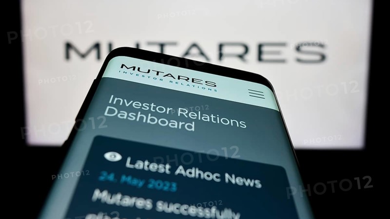 Stuttgart, Germany, 06-24-2023: Mobile phone with webpage of German investment company Mutares SE Co. KGaA on screen in front of logo. Focus on top-left of phone display