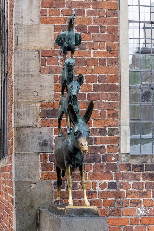 The famous bronze statue of the Bremen Town Musicians with the figures of a donkey, dog, cat and cockerel in Schoppensteelstraße, Old Town Bremen, Hanseatic City of Bremen, Germany