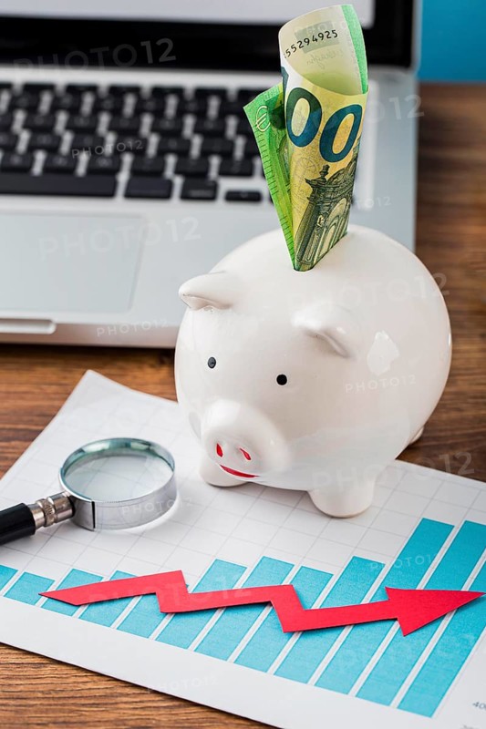 High angle office items with piggy bank growth chart