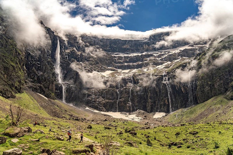 Hikers in the cloudy Cirque de Gavarnie basin, UNESCO World Heritage Site in the Pyrenees National Park near Gavarnie-Gèdre, France
