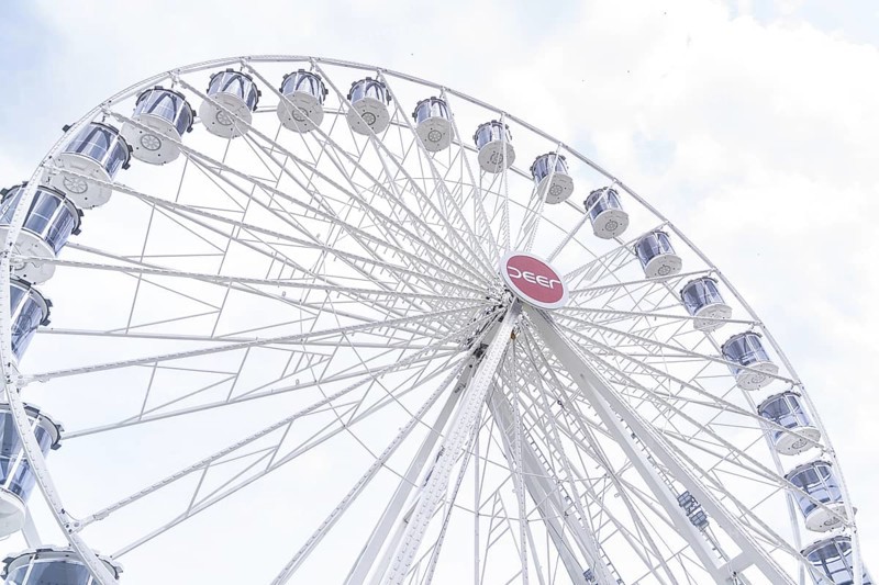 White Ferris wheel with distinctive gondolas in front of a slightly cloudy sky, Ferris wheel construction, Calw, Germany