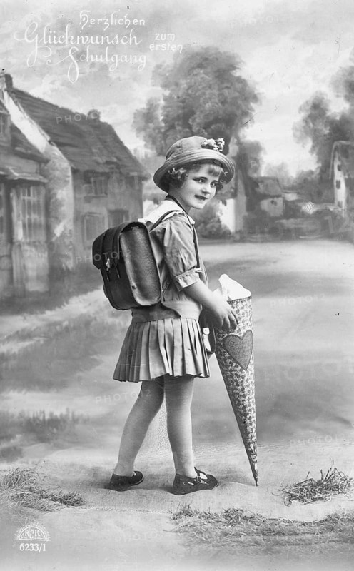 School enrolment, 1920s, A girl with a school bag looks back smiling on a country road, Historical photo
