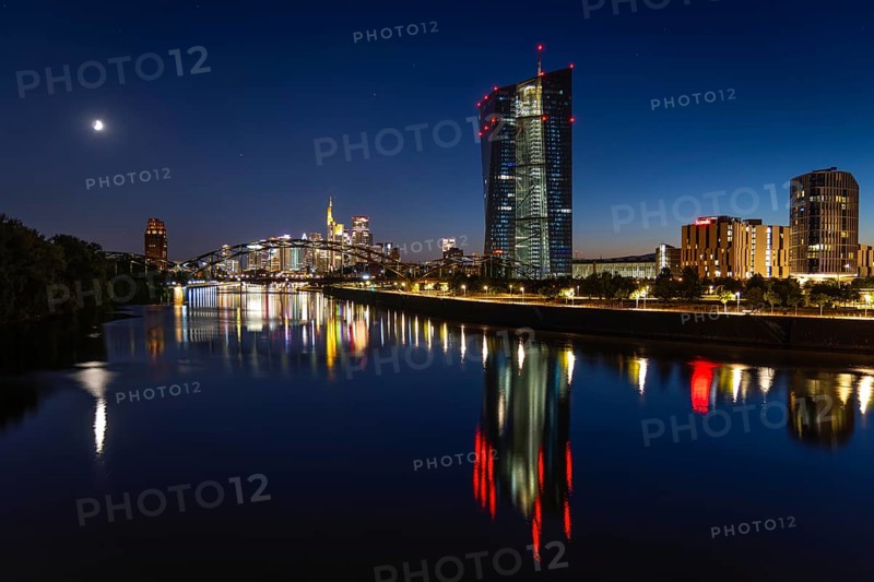 The European Central Bank (ECB) and the Frankfurt banking skyline are reflected in the calm waters of the Main at blue hour, Osthafen, Frankfurt am Main, Hesse, Germany