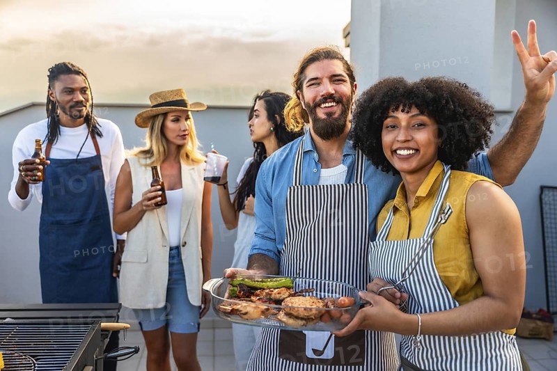 Chefs celebrating with friends on a rooftop, grilling delicious food, enjoying drinks, and sharing laughter during a vibrant summer evening