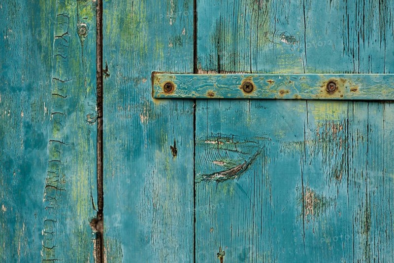 Weathered green wooden door with rusty metal accents in rustic style, background, texture, Montenegro, Balkans