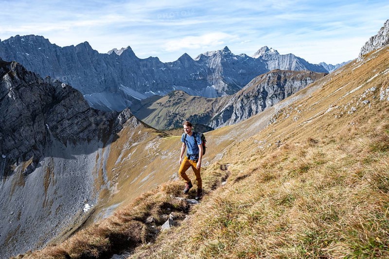 Mountaineers on a hiking trail at the Gamsjoch, picturesque mountain landscape in autumn, view of the rocky mountain ridge of the Hinterautal-Vomper chain, Rißtal in the Eng, Karwendel, Tyrol, Austria