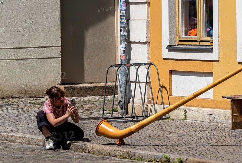 Young woman photographing an alphorn, Potsdam, Brandenburg, Germany
