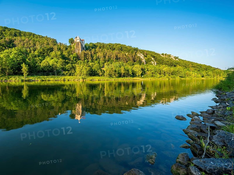 Prunn Castle on a steep cliff above the Altmühl Valley in the evening light, reflection in the river Altmühl as part of the Main-Danube Canal, near Riedenburg, Altmühl Valley nature park Park, Lower Bavaria, Germany