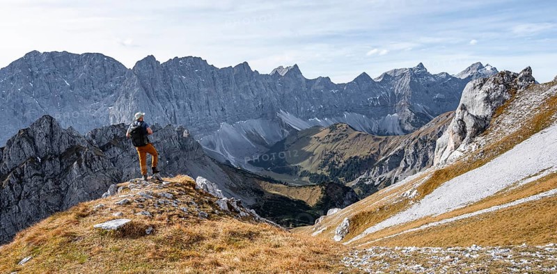 Mountaineers in front of a picturesque mountain landscape in autumn, view of the rocky ridge of the Hinterautal-Vomper chain, Rißtal in the Eng, Karwendel, Tyrol, Austria
