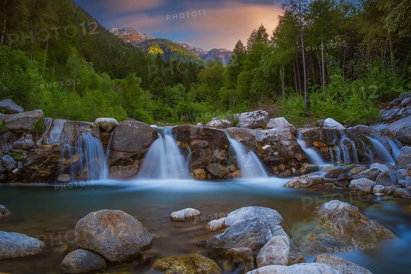 View of a waterfall of the Rio Plima stream in the evening light, long exposure, landscape photo, nature photo, landscape format, forest, trees, Dolomites, South Tyrol, mountains, Laces, Morter, Italy