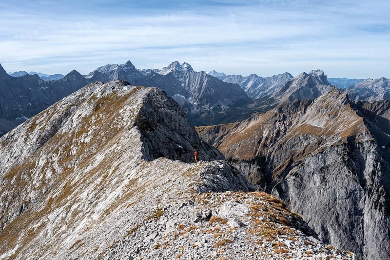 Mountain panorama, mountaineer on the ridge of the Gamsjoch, transition to the main summit of the Gamsjoch, behind western summit with summit cross, behind mountain ridge of the Hinterautal-Vomper chain, in autumn, Rißtal in the Eng, Karwendel, Tyrol, Austria