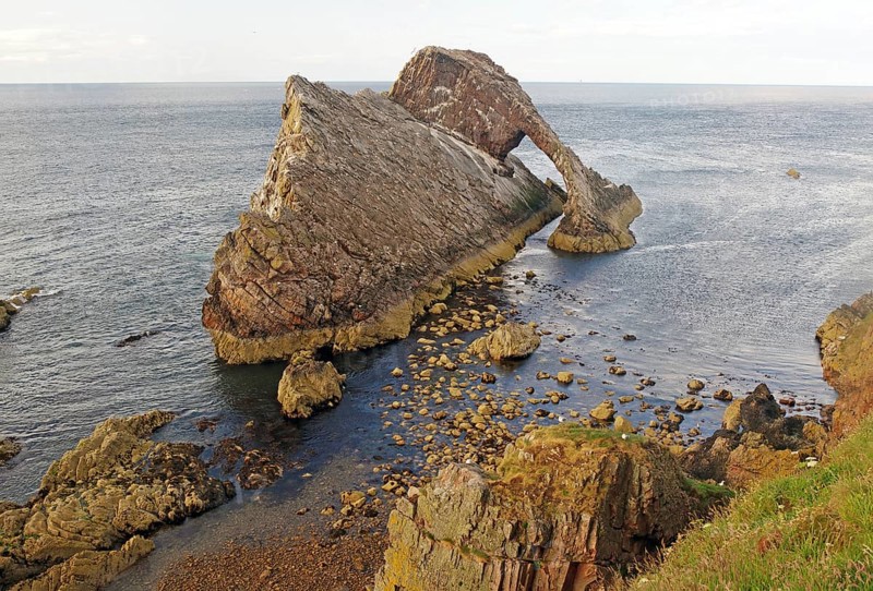 Impressive coastal view of a rock formation reaching far into the sea, Bow Fiddle Rock, Aberdeenshire, Buckie, Scotland, Great Britain