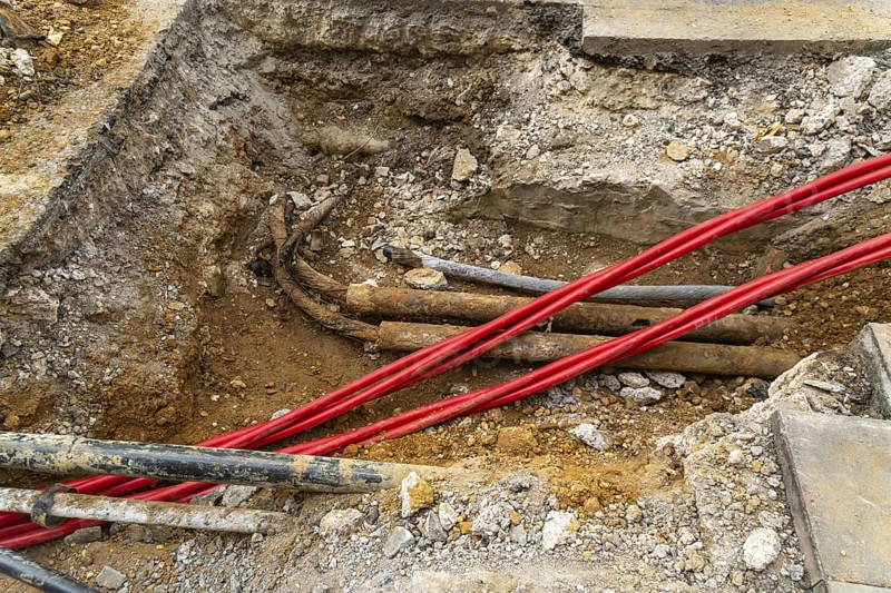 Underground cables and pipes under road surface, London, England, UK