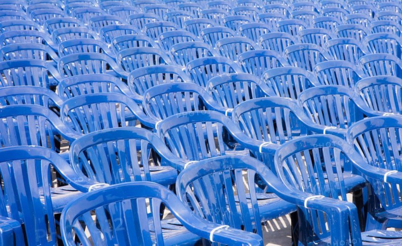 Many rows with a lot of blue pastic chairs